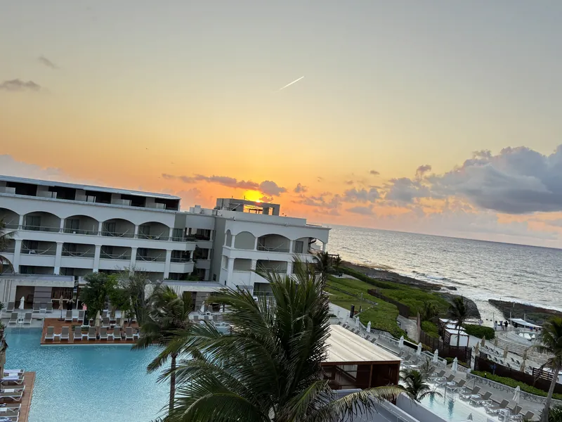 Sunrise over the pools and coastline at Hard Rock Riviera Maya